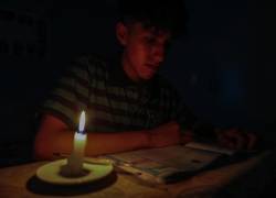 Un estudiante lee un texto a la luz de una vela este miércoles en Quito.