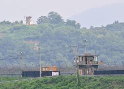 Un puesto de guardia de Corea del Norte (arriba) en la Zona Desmilitarizada de Corea (DMZ), se ve sobre una cerca militar de Corea del Sur (abajo) desde la ciudad fronteriza de Paju el 19 de julio de 2023.