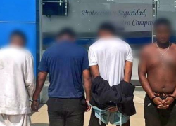 Los cuatro detenidos bajo custodia de agentes de seguridad.