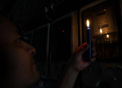 Fotografía de un ciudadano mirando su medidor de luz en medio de un apagón.