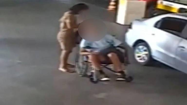 $!Captura de un video registrado por una cámara de seguridad de un parqueadero, cuando la mujer trasladó el cuerpo hacia la entidad bancaria.