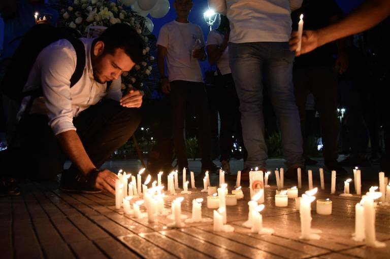 $!Un hombre enciende velas durante una vigilia contra la violencia en Cúcuta, Colombia, el 15 de abril de 2024.