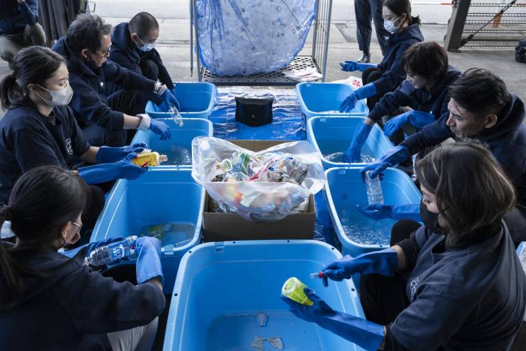$!Esta foto tomada a noviembre del 2022 muestra a personas limpiando y clasificando botellas de plástico, que se usan actualmente para el espectáculo de ballet Plastic que resalta el problema de la contaminación
