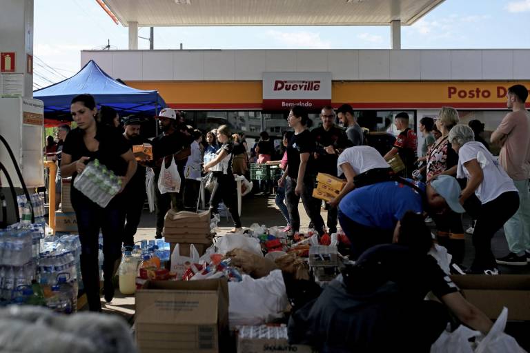 $!Voluntarios brindan alimentos, atención médica y ropa a personas rescatadas de casas inundadas en una gasolinera utilizada como punto de encuentro en Porto Alegre, estado de Rio Grande do Sul, Brasil, el 5 de mayo de 2024.