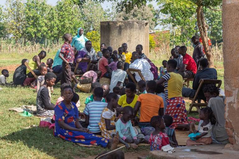 $!Musa Hasahya se sienta con algunos de sus hijos y nietos frente a la casa de su familia en el distrito de Butaleja.