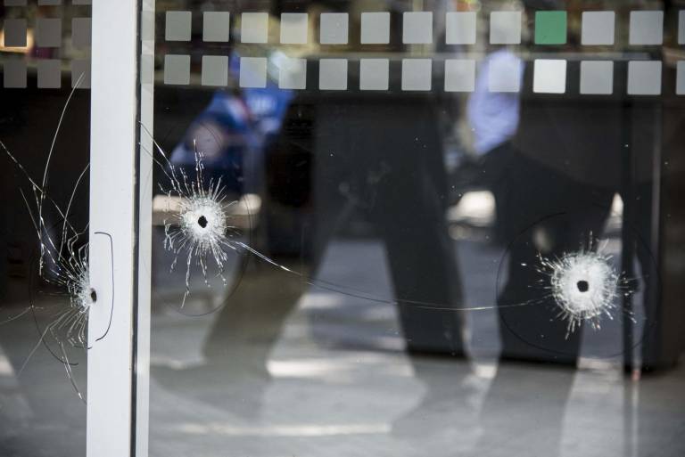 $!Imagen de impactos de bala en un escaparate de un supermercado de la familia de Antonela Roccuzzo, esposa del astro del fútbol argentino Lionel Messi, luego de que los agresores dispararan contra la fachada del local cerrado.