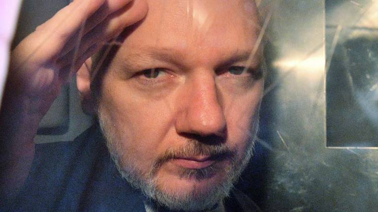 El fundador de WikiLeaks, Julian Assange, hace un gesto desde la ventana de una furgoneta de prisión mientras lo sacan del Tribunal de la Corona de Southwark en Londres el 1 de mayo de 2019, después de haber sido sentenciado a 50 semanas de prisión por violar las condiciones de su libertad bajo fianza en 2012.