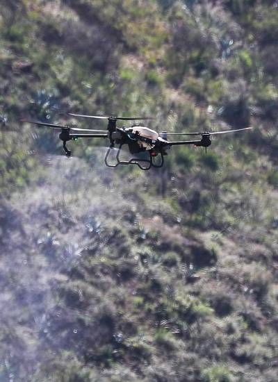 Fotografía de un dron forestal Agras T20, de tecnología china, lanzando 20.000 semillas de especies nativas que apuntan a recuperar la cobertura vegetal del árido y erosionado cerro Casitagua, afectado en parte por un incendio el año pasado, el 02 de mayo de 2024 en Quito (Ecuador).