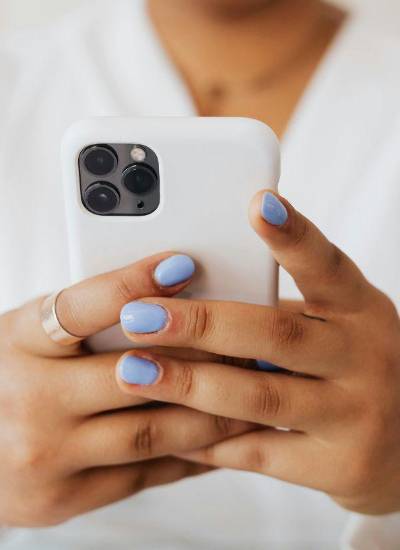 Mujer navegando en su dispositivo móvil iPhone.