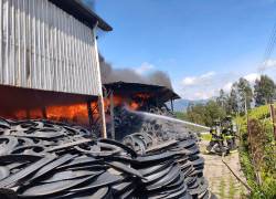 Bomberos controlando las llamas del incendio en una recicladora de Quito.