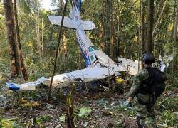 Un soldado colombiano de pie junto al avión que colisionó y dio inicio al drama de los cuatro niños perdidos en la selva colombiana.