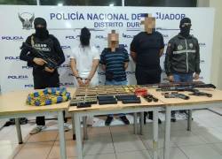 Fotografia que muestra a los tres aprehendidos junto a las armas y municiones incautadas.