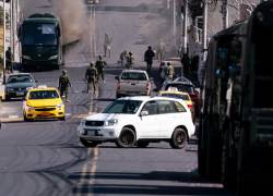 Un bus estacionado cerca de la Quinta Locoa, en Latacunga, donde se realiza la entrega de créditos para el fortalecimiento del sector turístico, se incendió, y personal militar trabaja para apagar el fuego. Fotos: William López / API