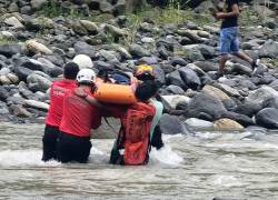 Fotografía que muestra a rescatistas y voluntarios trasladando el cuerpo de la víctima.