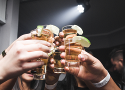 Imagen de referencia de varias personas haciendo un brindis con tequila.
