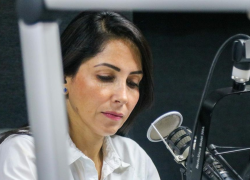 Fotografía referencial de Luisa González frente a un micrófono.