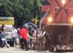 Captura de video en el que se observa al hombre en silla de ruedas ser empujado por varios sujetos.