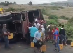 Captura de video en la que se observa a varios ciudadanos extrayendo cervezas del camión accidentado.