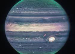 Fotografía cedida por la NASA donde se aprecia una imagen de júpiter tomada por la cámara de infrarrojo cercano (NIRcam) del Telescopio Espacial James Webb (JWST) y procesada por Judy Schmidt a partir de tres filtros: F360M (rojo), F212N (amarillo-verde) y F150W2 (cian), y alineación debido a la rotación del planeta.