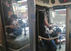 En Santo Domingo, una mujer maneja un autobús junto a su hijo para ayudarlo con las tareas.