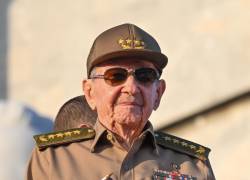 El expresidente cubano Raúl Castro sostiene una bandera cubana durante la conmemoración del Primero de Mayo (Día del Trabajo).