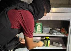 Agente revisando el interior de un taller de fabricación de municiones en Durán.