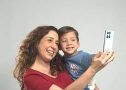 Una mujer tomándose una foto junto a su bebé.