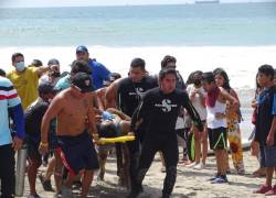 Un grupo de personas traslada al bañista hacia una ambulancia.