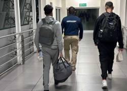 Los dos jóvenes británicos a punto de ser deportados, acompañados por un agente de migración.