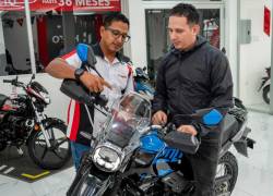 Vendedor de tienda Hero en Guayaquil muestra varias características de una motocicleta
