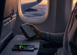 En la imagen aparece un pasajero cargando su celular con una batería portátil.