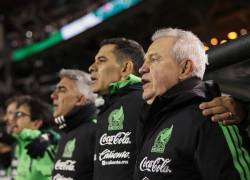 Javier Aguirre cantando el himno de México junto a su staff técnico.