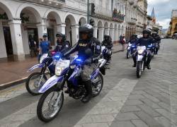 Fotografías de un grupo de policías patrullando el centro histórico de la ciudad de Cuenca, cerca de la Plaza Calderón.