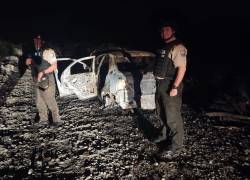 Fotografía que muestra a policías junto al vehículo incinerado que podría estar vinculado al asesinato de la magistrada.