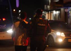 Un agente de Policía lleva a un ciudadano detenido hacia un vehículo de la institución, en el cantón de Durán, en la provincia de Guayas.