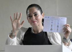 La candidata presidencial Luisa González, con un chaleco antibalas, muestra su boleta antes de emitir su voto.