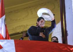 El candidato izquierdista a la presidencia de Perú Pedro Castillo saluda a seguidores desde un balcón de la sede de su partido Perú Libre.