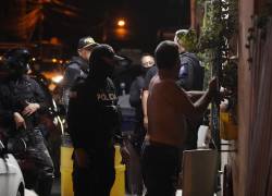 Un agente policial Policia revisa a una persona en un recorrido ejecutado en el toque de queda.