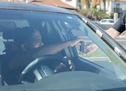 Persona mostrando su licencia de conducir, en una foto referencial.