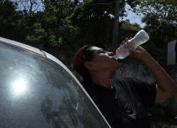 Ciudadana en Guayaquil tomando agua helada en medio de las altas temperaturas, en una imágen de archivo.