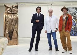El artista británico Thomas Houseago (C) posa con el actor y ahora escultor Brad Pitt (D) y el músico australiano Nick Cave durante la apertura de la exhibición en la que Brad presenta su obra.