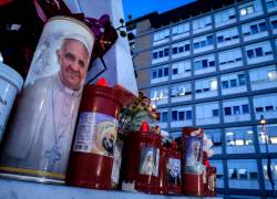 Una vela con la imagen del Papa Francisco, al pie de la estatua de San Juan Pablo II en las afueras del Hospital Universitario Gemelli, en Roma, donde el Papa Francisco se encuentra hospitalizado.
