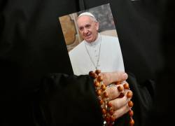 Una monja sostiene una imagen del Papa Francisco y un rosario.