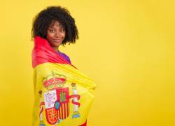 Mujer posa con la bandera de España, país con diferentes vías para conseguir una residencia.