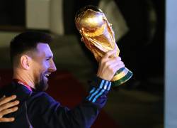 Lionel Messi saluda con el trofeo del Mundial de Fútbol Catar 2022 en su llegada al Aeropuerto Internacional de Ezeiza.