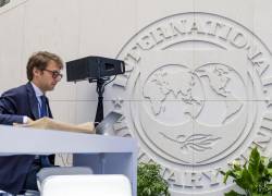 Una persona trabaja en su computadora portátil en el atrio del edificio del Fondo Monetario Internacional (FMI), en Washington, D.C.