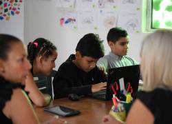 Los estudiantes venezolanos Valerith Ortega (2do-I), Randy Ordóñez (C) y Enrique Romero se preparan para tomar exámenes de matemáticas y lenguaje durante las Olimpíadas Nacionales Recreativas en la ciudad de Montalbán, Estado Carabobo, Venezuela, el 15 de junio de 2024.