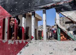 Niños palestino niños detrás de una puerta de un área cerrada, pintada con los colores de la bandera de Palestina