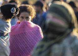 Fotografía de una inmigrante venezolana que mira hacia un soldado de la Guardia Nacional de Texas después de cruzar el Río Grande desde México el 18 de diciembre de 2023 en Eagle Pass, Texas.