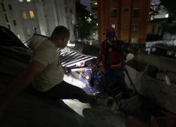 Integrantes del Cuerpo de Bomberos rescatan a una persona este miércoles, en Caracas.